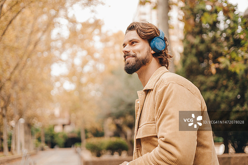 在公园里听音乐的Z世代白人男子特写图片素材