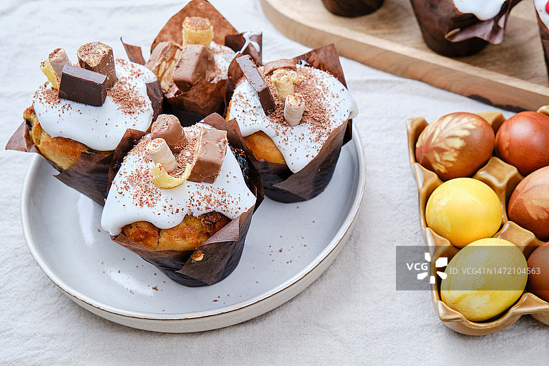 家庭厨房餐桌上带有巧克力装饰和彩绘彩蛋的复活节蛋糕图片素材