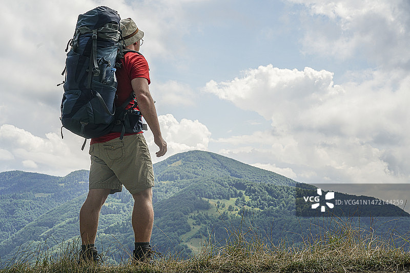 背着背包的游客站在山顶图片素材