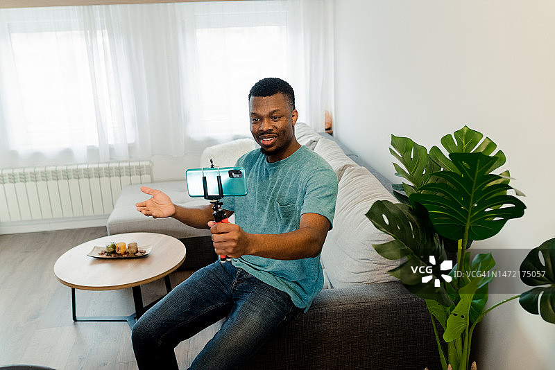快乐的非裔美国男子在家拍摄Vlog的肖像图片素材
