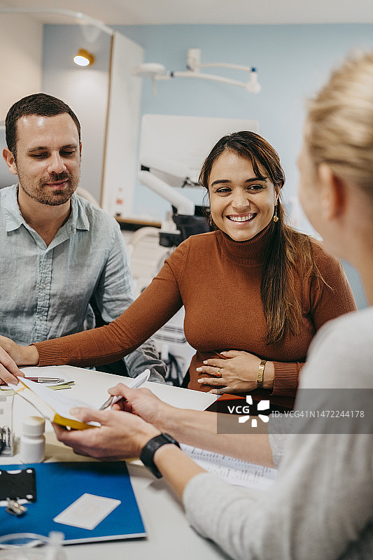 幸福的准父母在妇产科诊所接受医生建议图片素材