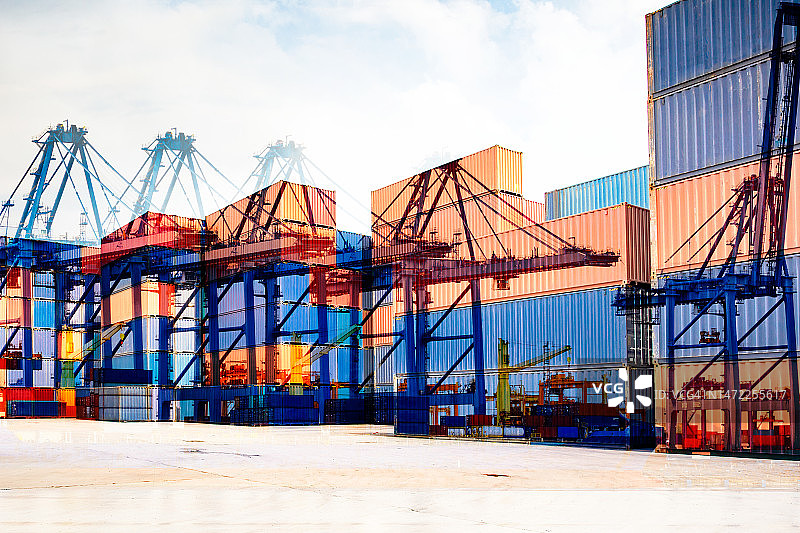 工业起重机在堆场吊装集装箱的双重曝光图片素材