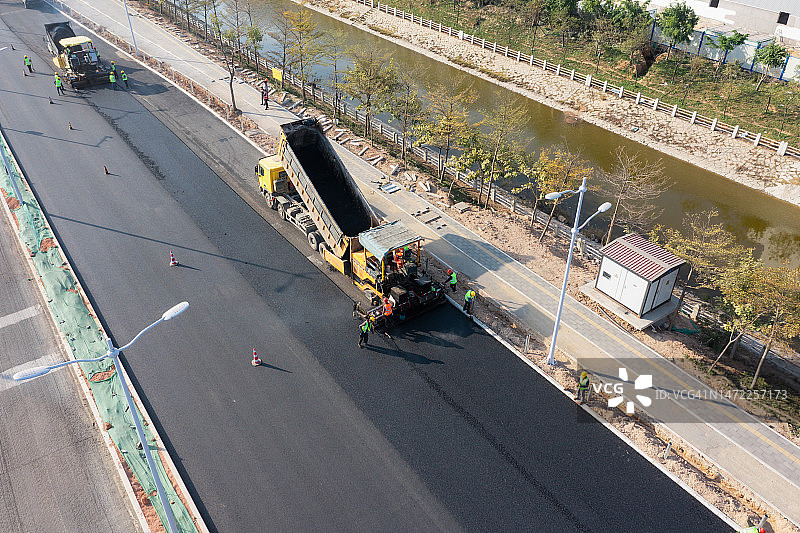 铺路机械和工人在铺设沥青路面图片素材