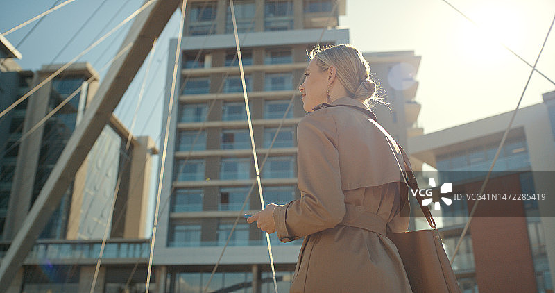 女商人走在城市户外，为了旅行、机会和观光。创业者带着包和城市建筑行走，同时思考着事业、愿景和梦想与城市景观图片素材