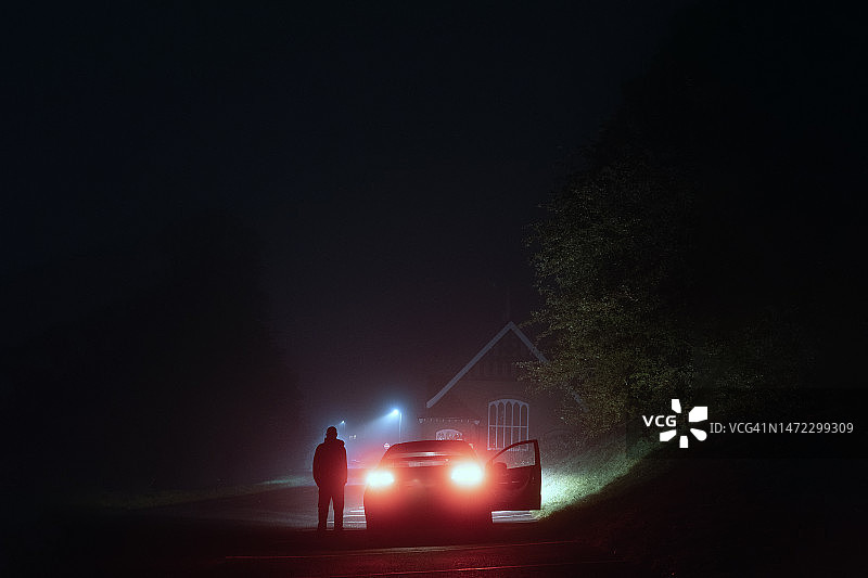 雾夜中站在汽车旁的神秘男人图片素材