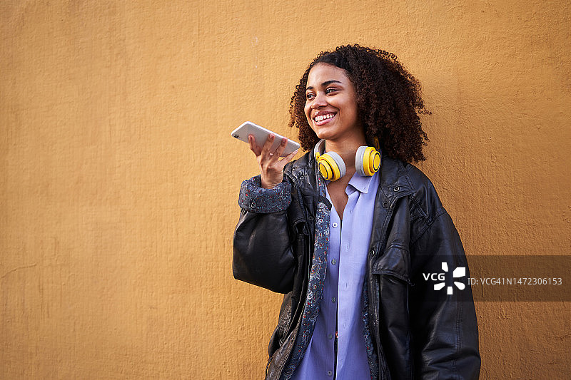 用手机发送语音消息的非洲裔女人图片素材