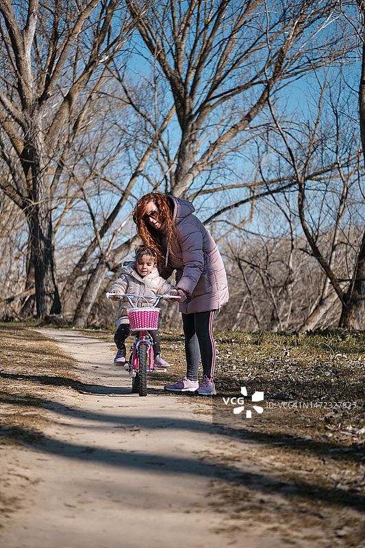 母亲教女儿骑自行车图片素材