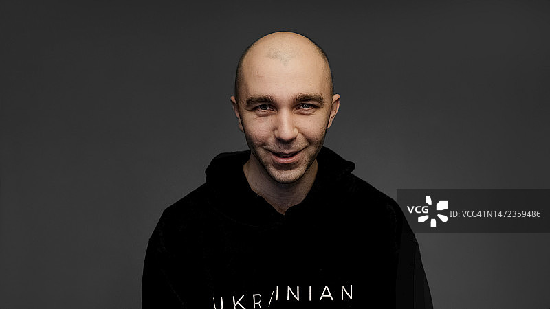 时髦的光头男人，深灰色影棚背景图片素材