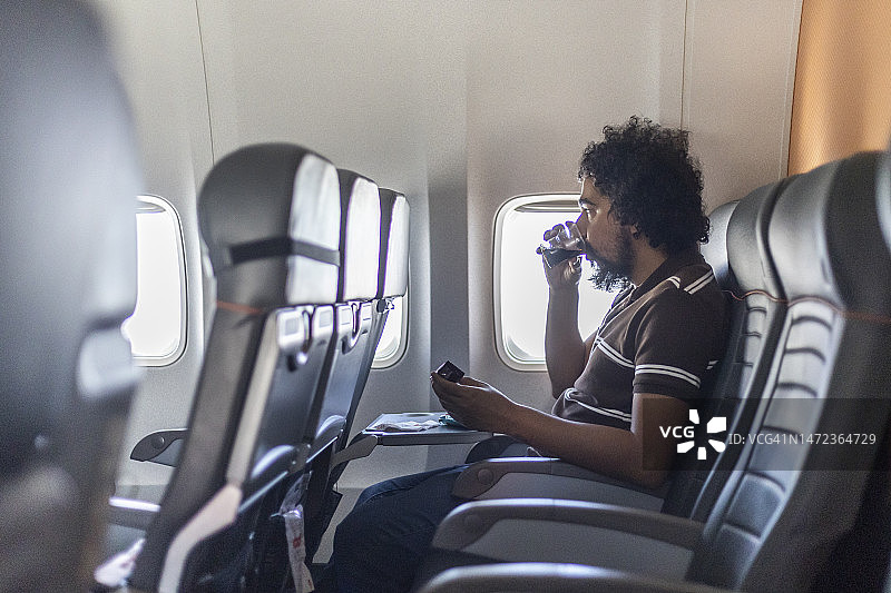 黑人男子在商业航班上用餐图片素材