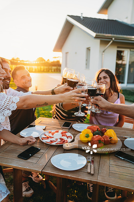 朋友们在日落时分一起举杯红酒图片素材