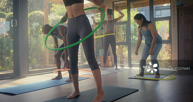 健身房里的人们用呼啦圈和瑜伽锻炼身体图片素材