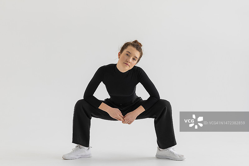 穿着黑色衣服在白色背景前表演的年轻嘻哈舞者图片素材