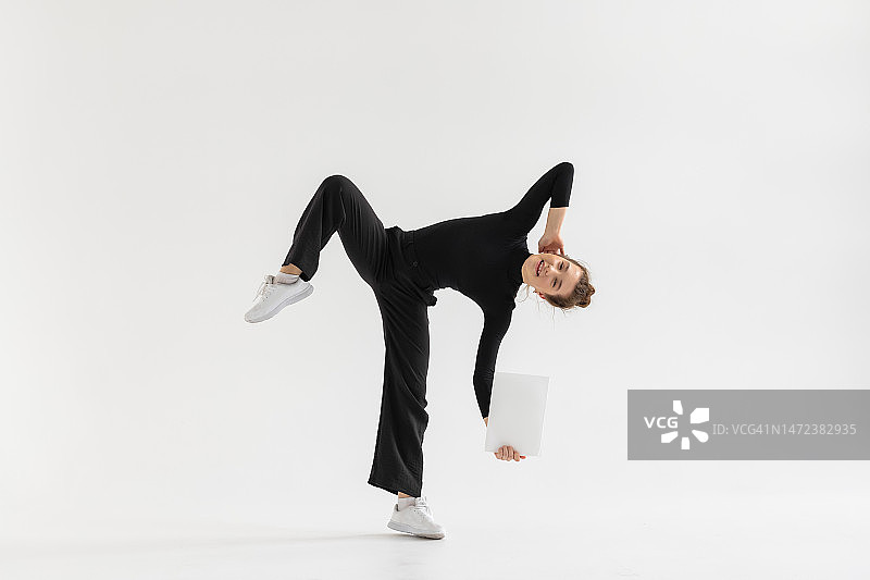 手持空白白纸在白色背景上表演的年轻嘻哈舞者图片素材