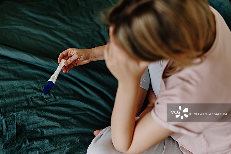 女人在床上拿着孕检棒图片素材