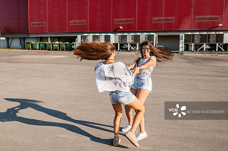 两位女人在停车场旋转图片素材