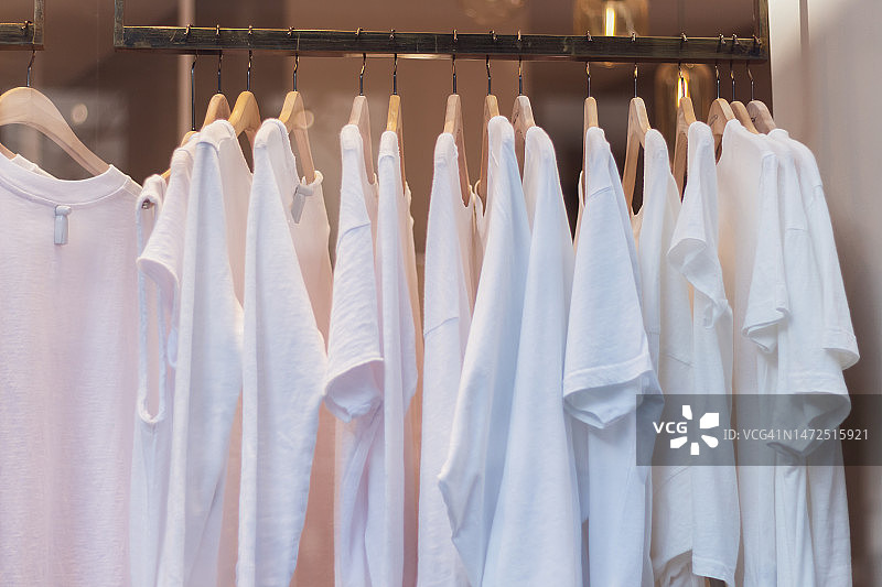服装店橱窗里悬挂的白色T恤图片素材