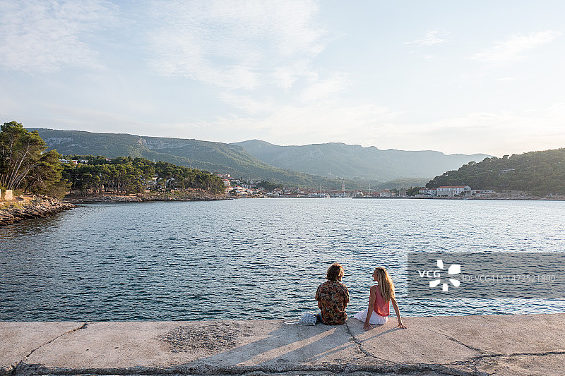 无人机视角下在码头上观看日落的夫妇图片素材