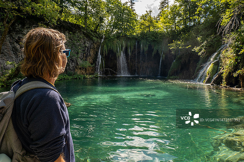 男人在阳光下欣赏清澈的湖水图片素材