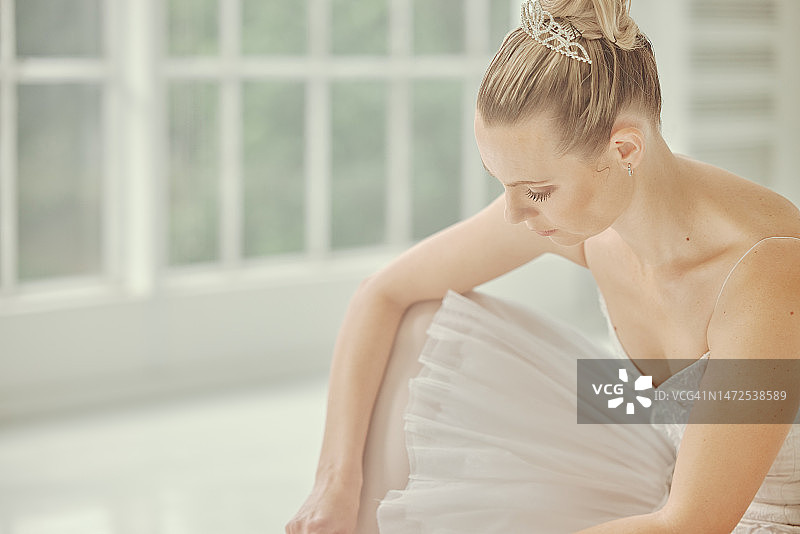 芭蕾舞：舞蹈演员在舞蹈室内系鞋带，准备演出图片素材