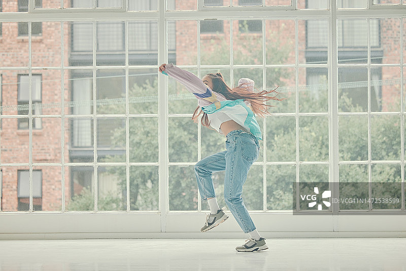 在工作室里，女性随着音乐跳舞，进行训练、运动和表达图片素材