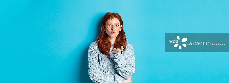 穿着毛衣，嘟着嘴，凝视着镜头的可爱少女图片素材