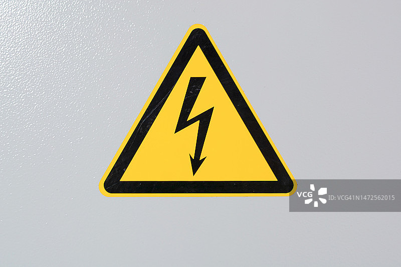 灰色背景上的黄色图标：电气电压警告标志图片素材