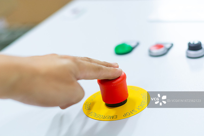 工人按下停止按钮，紧急红色按钮图片素材