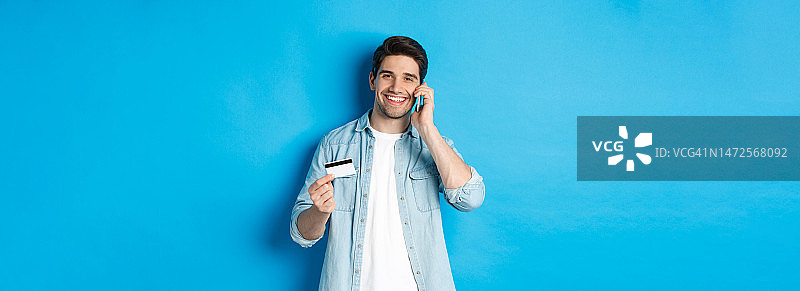 站在蓝色背景前的年轻男子肖像图片素材