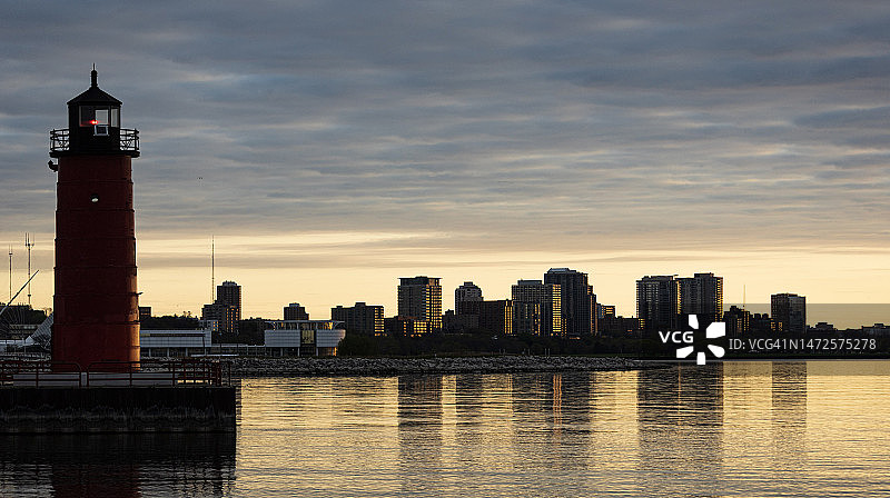 日落时分美国密尔沃基海边灯塔剪影图片素材