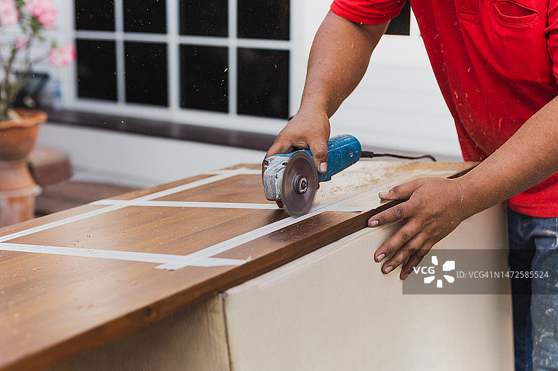 木匠用电动圆锯切割木材的手图片素材