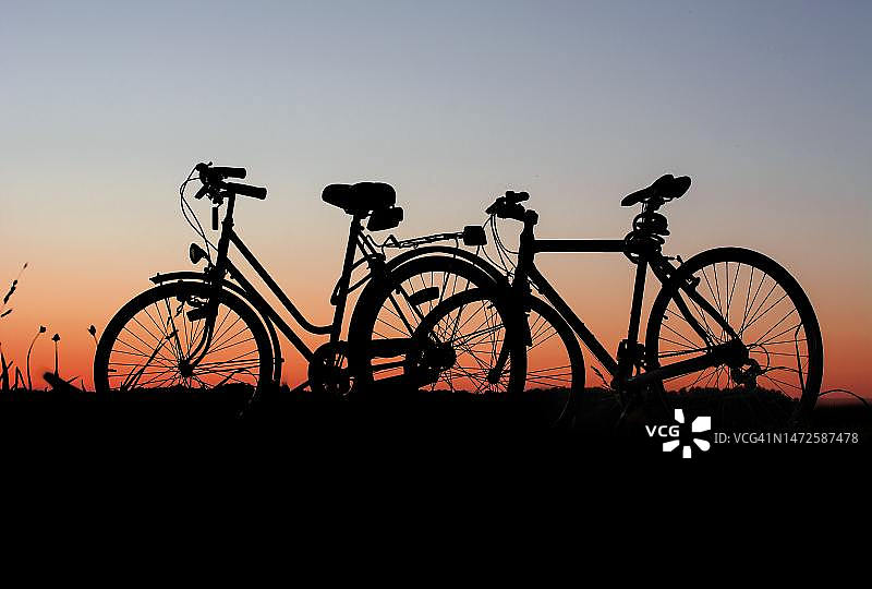 日落时分印度尼西亚田野上的自行车剪影图片素材