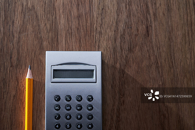 马来西亚木桌上的计算器和铅笔高角度视图图片素材