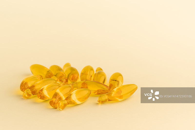 黄色背景上的Omega-3鱼油保健胶囊图片素材