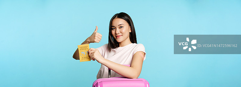 医疗健康与旅游，接种新冠疫苗的亚洲微笑女孩图片素材