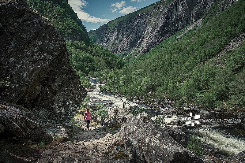 在挪威哈当厄尔高原国家公园瀑布河边徒步的女人图片素材