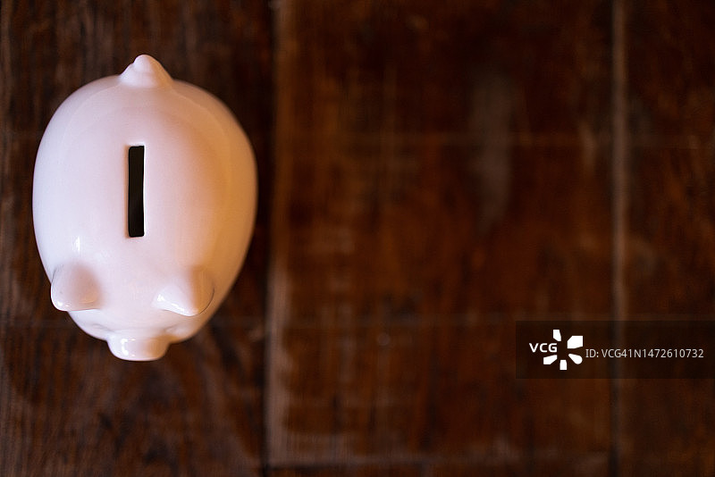 木质表面上的小白猪储蓄罐图片素材