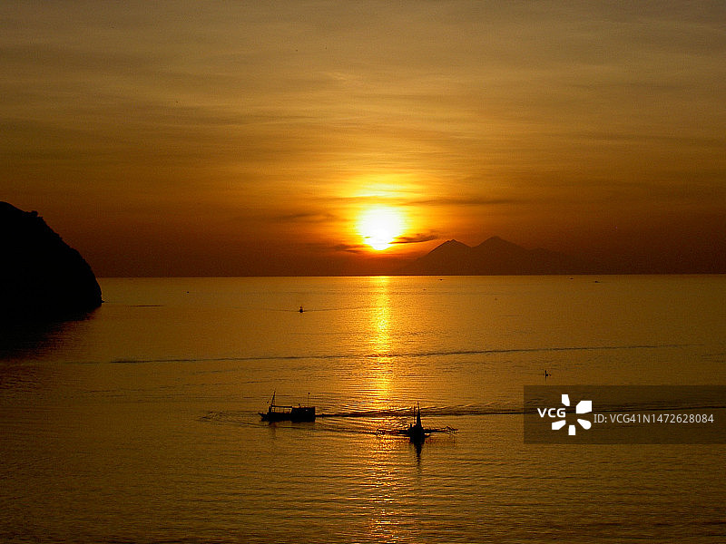 印度尼西亚的橘色天空下的壮丽海景图片素材