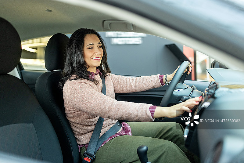 中年妇女在汽车展厅检查要购买的汽车图片素材