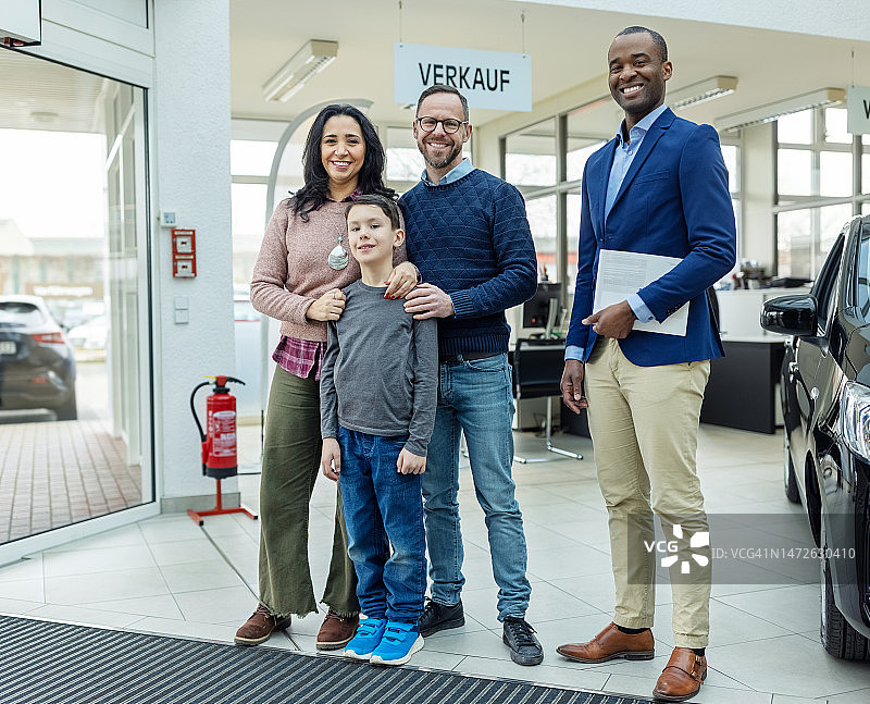 汽车经销商与家人在汽车展厅的合影图片素材