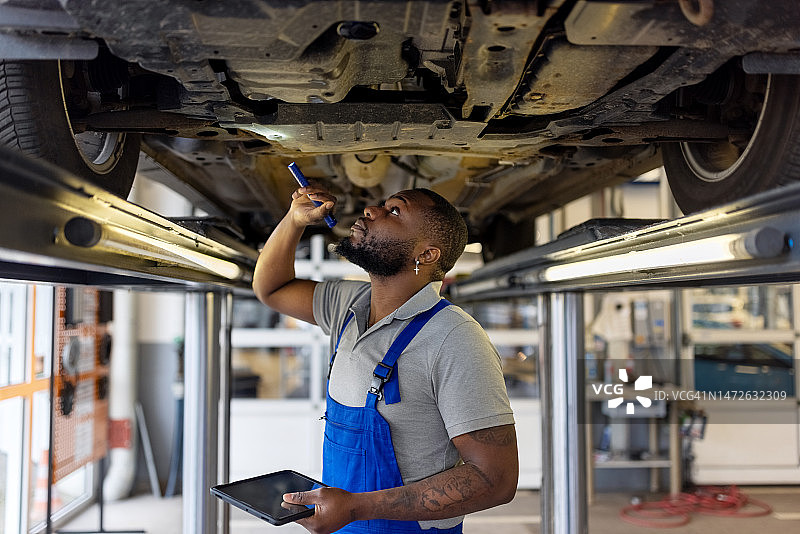 汽车维修技师检查举升汽车刹车片图片素材