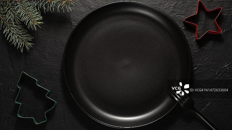 带有黑色陶瓷空盘的圣诞餐桌，配有冷杉树枝和装饰品图片素材
