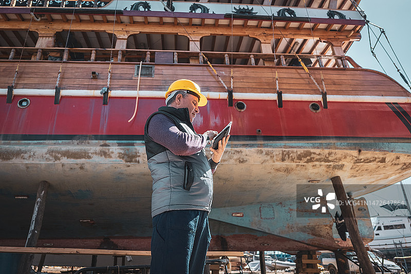 在造船厂内使用数字平板电脑进行项目的工程师图片素材