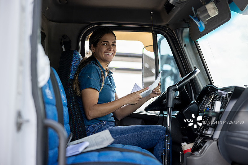 快乐的女卡车司机对着镜头微笑图片素材