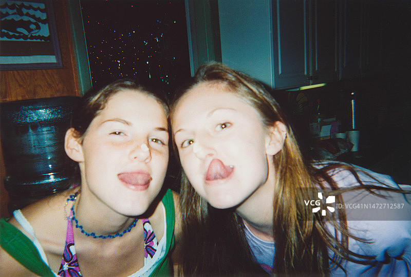 朋友们快乐地参加聚会，朋友们做着有趣的鬼脸吐舌头，2000年代Y2K风格复古照片图片素材