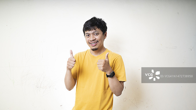 做出竖起大拇指手势的英俊青年图片素材