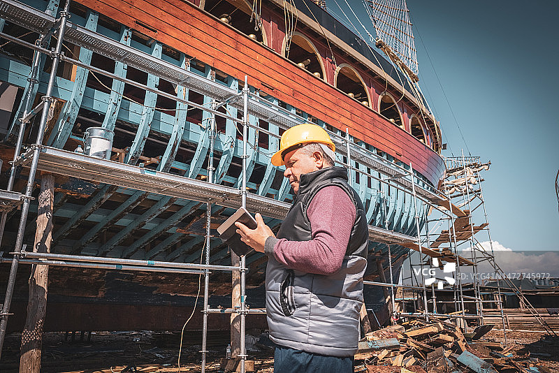 在造船厂内使用数字平板电脑进行项目的工程师图片素材