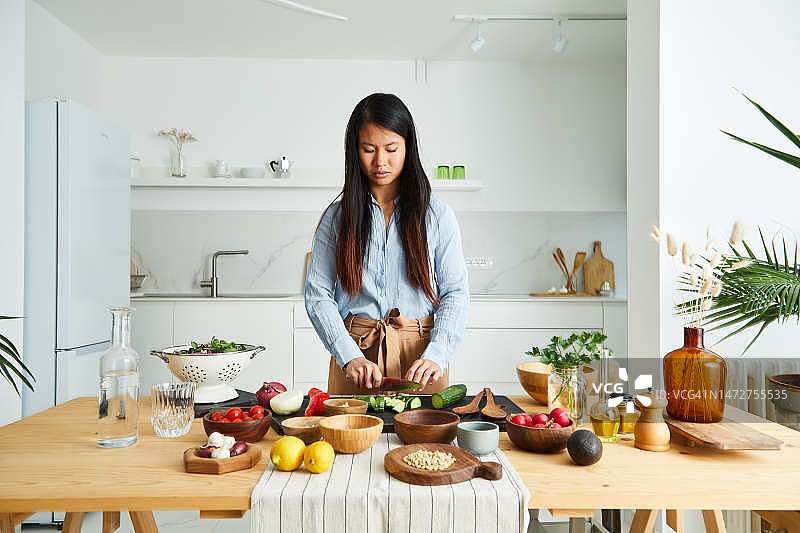 在厨房准备纯素食物的优雅亚洲女孩图片素材