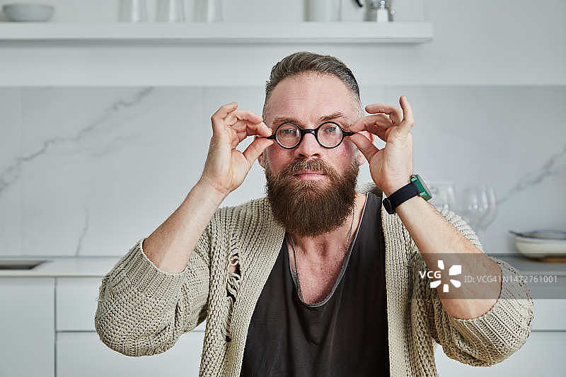 舒适地坐着并戴上眼镜的留胡子男人图片素材