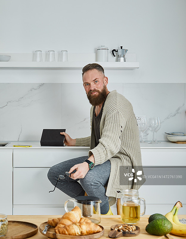 舒适地坐着读书的络腮胡男人图片素材