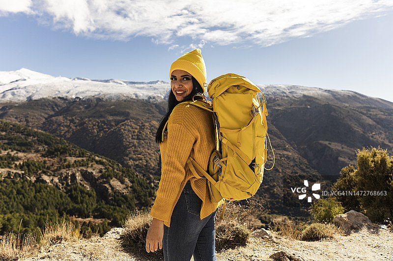 西班牙裔女士在山上背包旅行，看着镜头图片素材